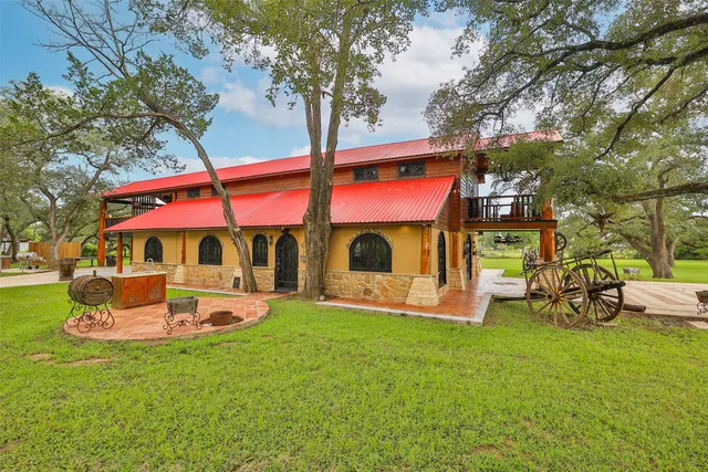 a front view of a house with garden and sitting area