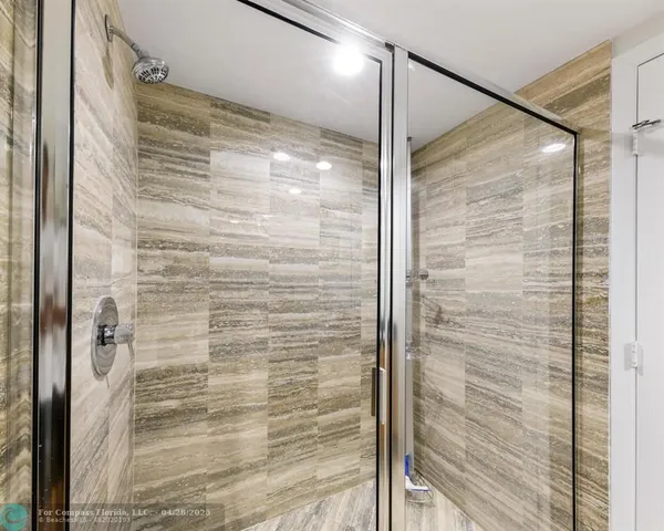 a bathroom with a glass door shower and a sink