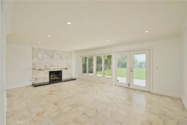 a view of an empty room with a fireplace and a window