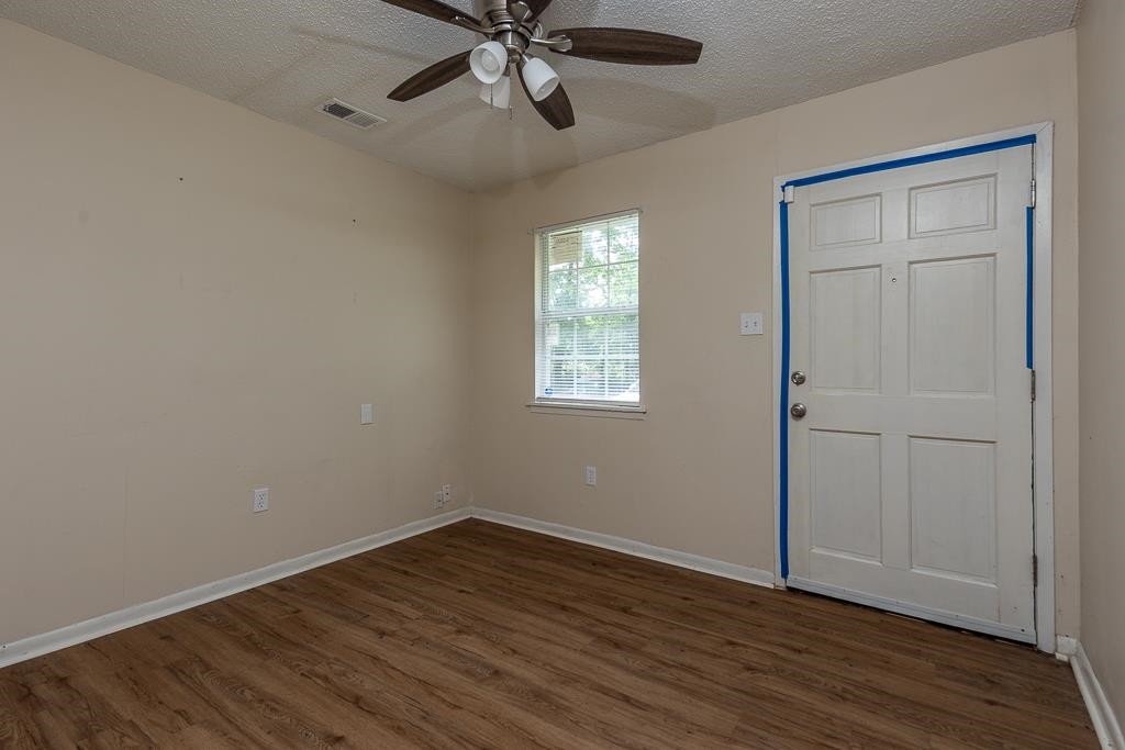 1871 Gooch Road Memphis, TN 38109 - Photo 3 of 13 a view of an empty room with wooden floor and a window