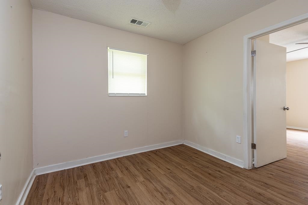 1871 Gooch Road Memphis, TN 38109 - Photo 4 of 13 an empty room with wooden floor and windows