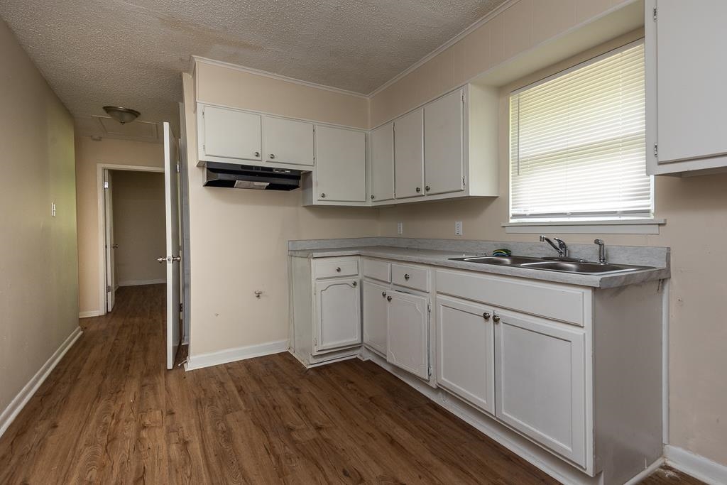 1871 Gooch Road Memphis, TN 38109 - Photo 5 of 13 a kitchen with wooden floors and white appliances