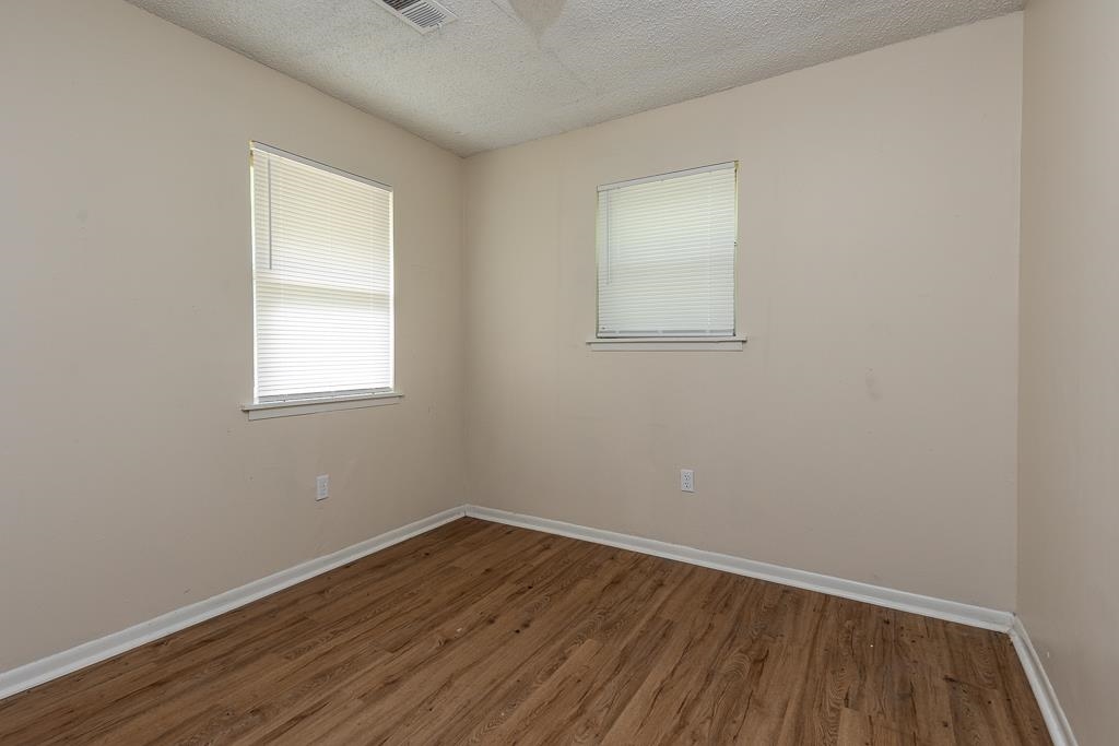 1871 Gooch Road Memphis, TN 38109 - Photo 8 of 13 an empty room with wooden floor and windows