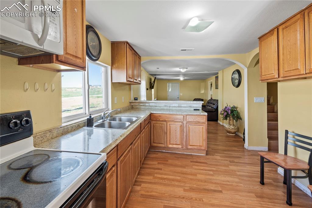 5025 Lauppe Road Yoder, CO 80864 - Photo 10 of 50 a large kitchen with stainless steel appliances granite countertop a sink and cabinets