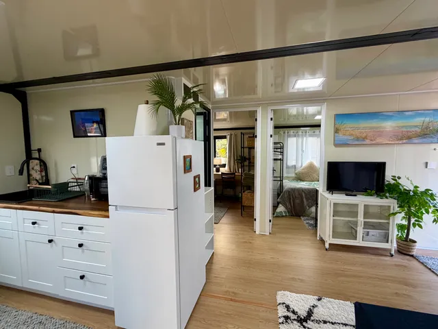a kitchen with furniture a flat screen tv and a refrigerator