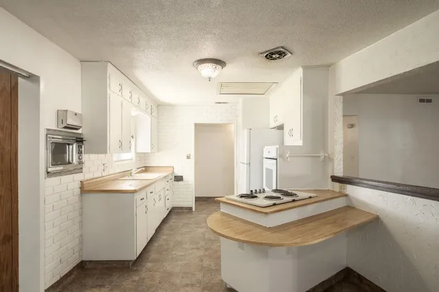 a kitchen with refrigerator and white cabinets