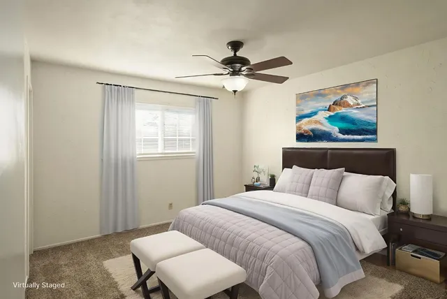 an empty room with a window and a fan