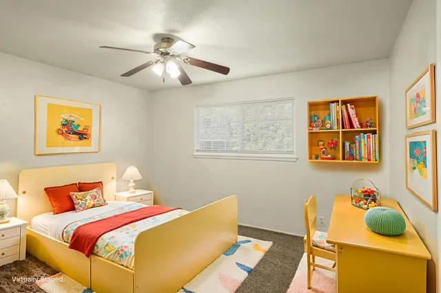 an empty room with a chandelier fan and windows