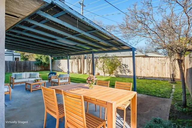 a view of backyard with table and chairs and wooden fence