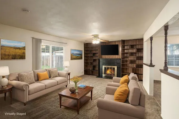 a view of a livingroom with a fireplace cabinet and window