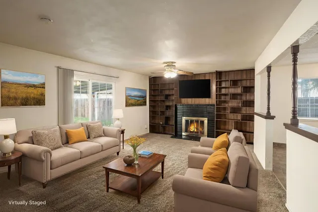 a view of a livingroom with a fireplace cabinet and window