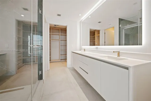 a spacious bathroom with a sink a large mirror and a shower