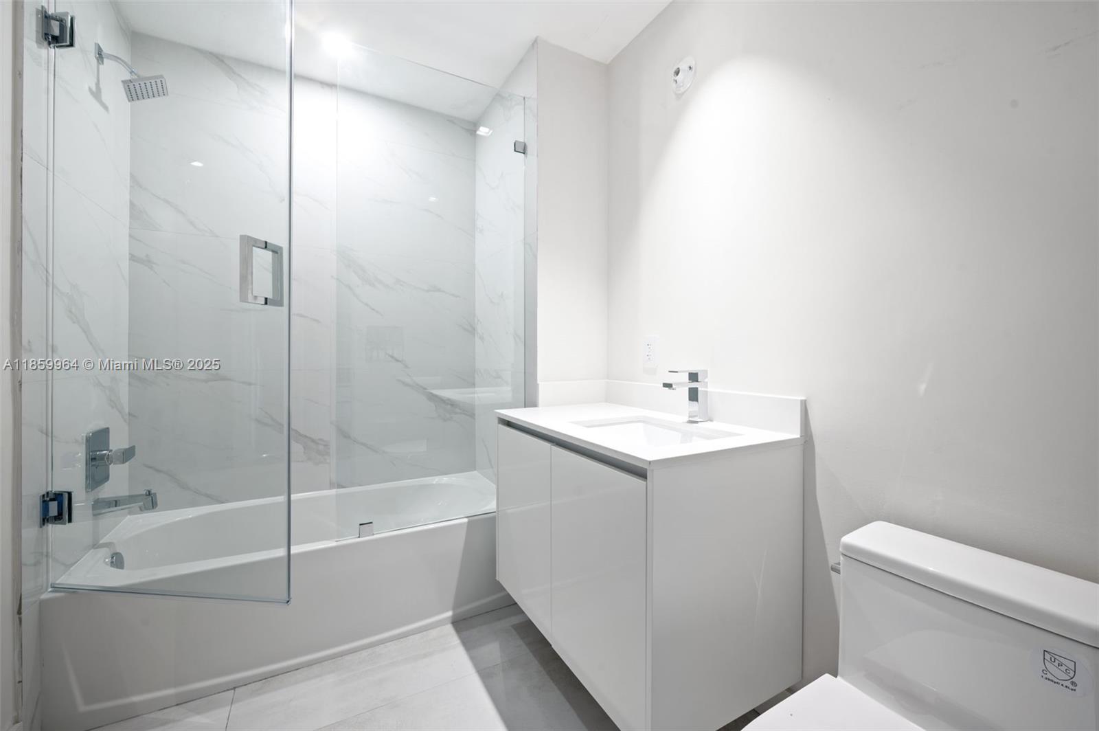 700 Northeast 24th Street, Unit 1406 Miami, FL 33137 - Photo 26 of 55 a bathroom with a shower a sink and a toilet