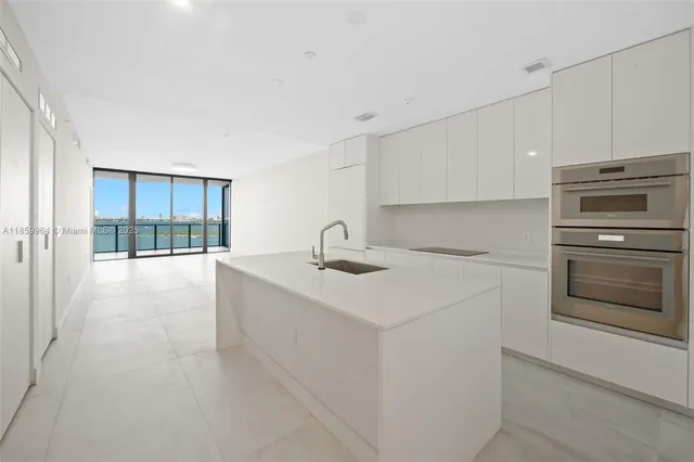 a kitchen with white cabinets and white appliances