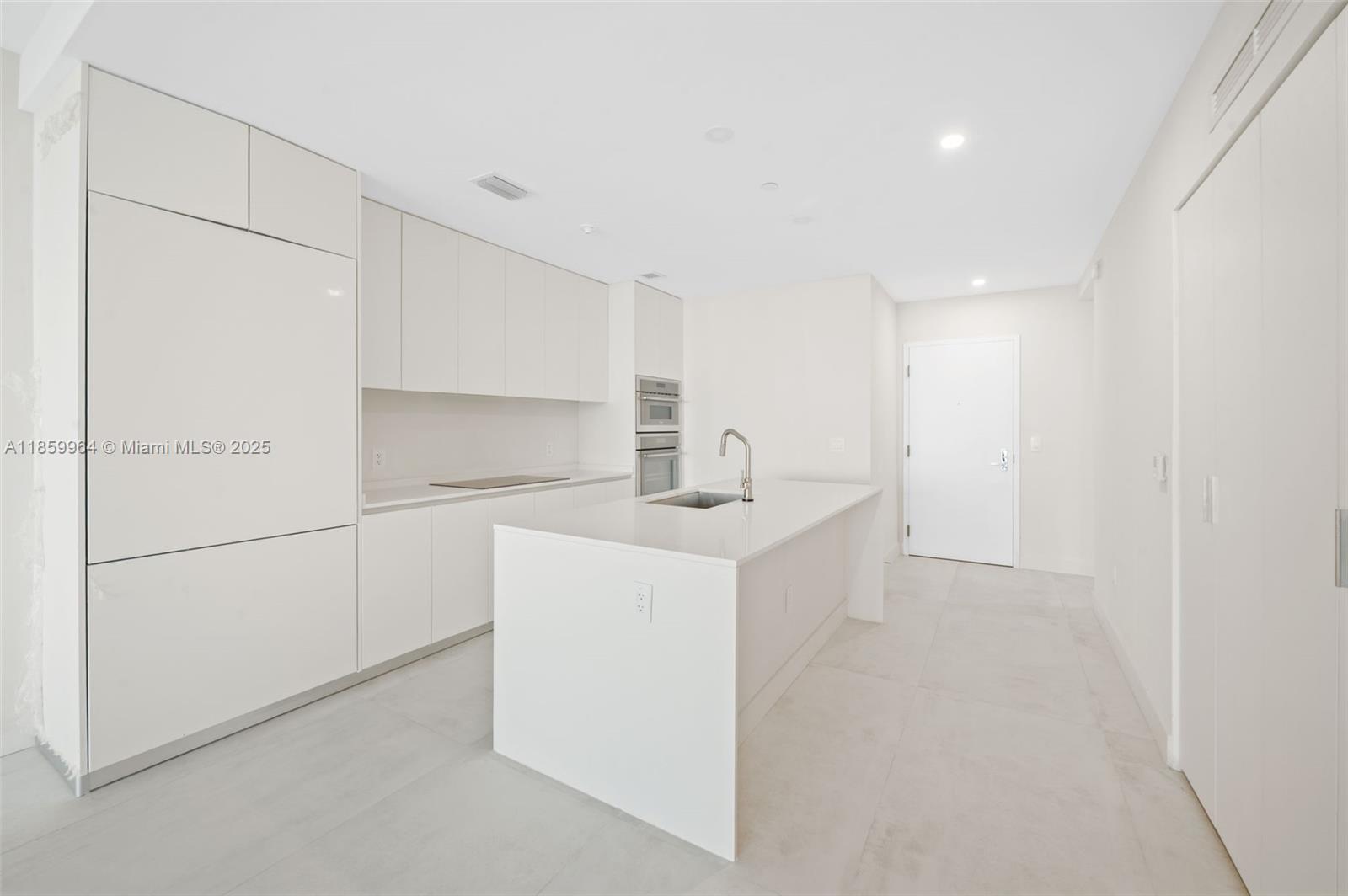 700 Northeast 24th Street, Unit 1406 Miami, FL 33137 - Photo 10 of 55 a kitchen with white cabinets and white appliances