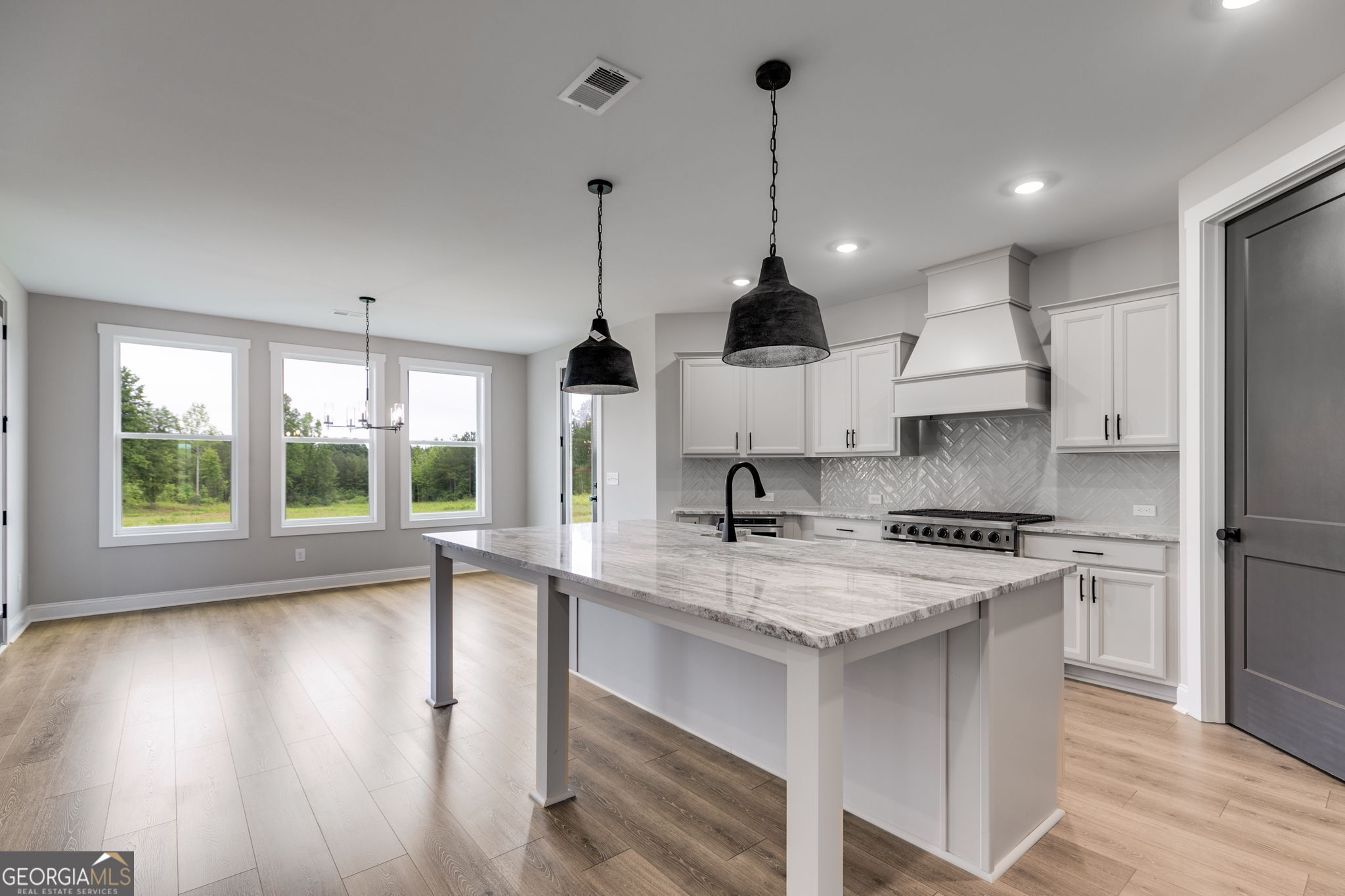 1611 Bethesda Church Road Carrollton, GA 30117 - Photo 17 of 45 a kitchen with stainless steel appliances granite countertop a sink a stove a refrigerator and a wooden floor