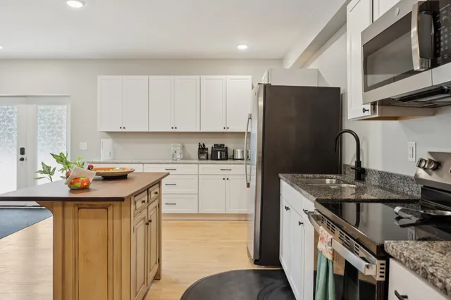 a kitchen with stainless steel appliances granite countertop a sink stove and refrigerator