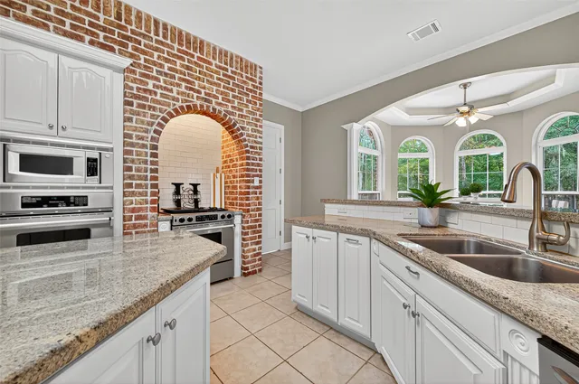 a kitchen with stainless steel appliances granite countertop a sink a stove and cabinets