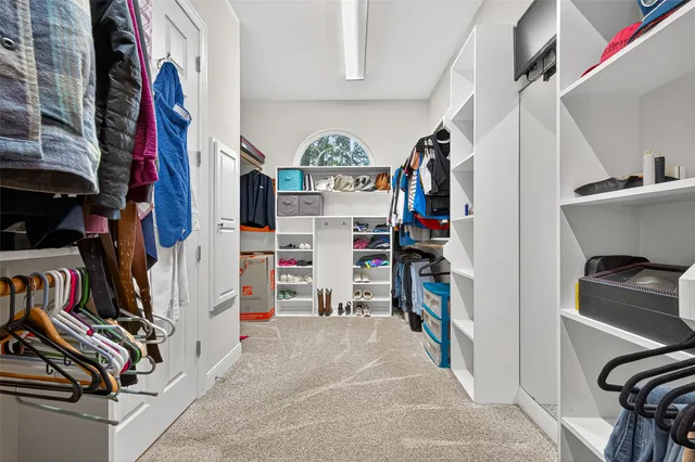 a view of walk in closet with clothes and shoes