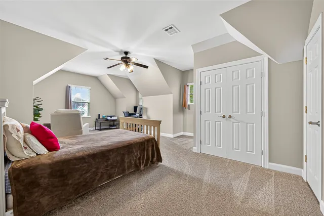 a bedroom with a bed and a ceiling fan