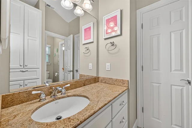 a bathroom with a granite countertop double vanity sink and a mirror