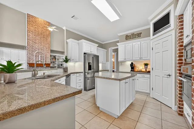 a kitchen with stainless steel appliances granite countertop a sink and a refrigerator