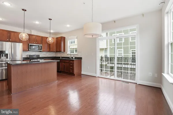 a kitchen with stainless steel appliances granite countertop a stove top oven a sink with wooden floors