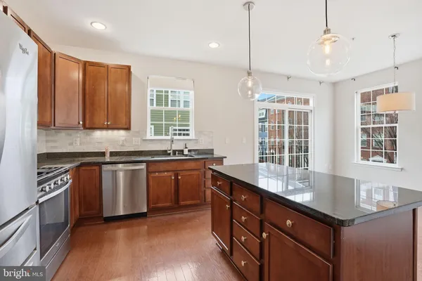 a kitchen with granite countertop cabinets stainless steel appliances a sink and a window
