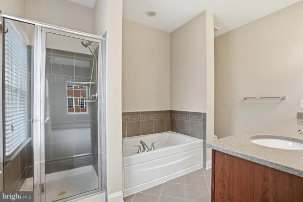 a bathroom with a granite countertop bathtub shower and toilet