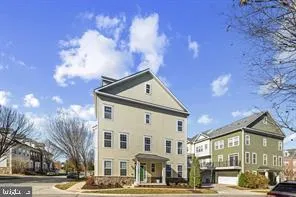 a front view of a building with lot of cars and trees