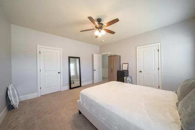 a bedroom with a large bed and a ceiling fan