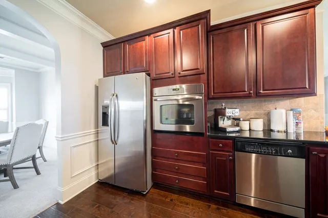 a kitchen with stainless steel appliances granite countertop a refrigerator and a stove top oven