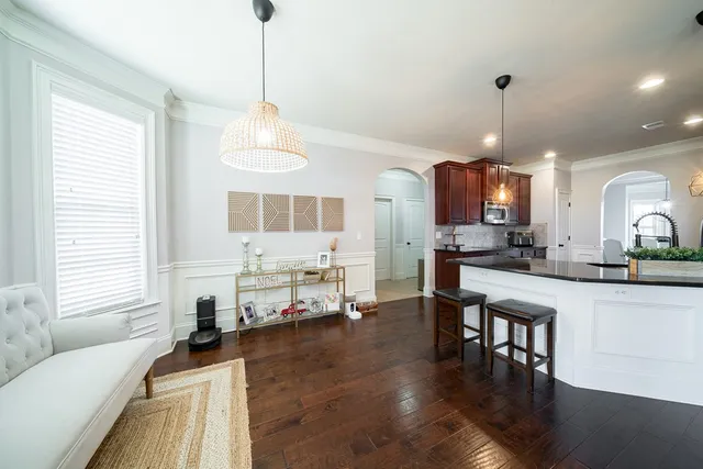 a living room with kitchen island furniture and a chandelier