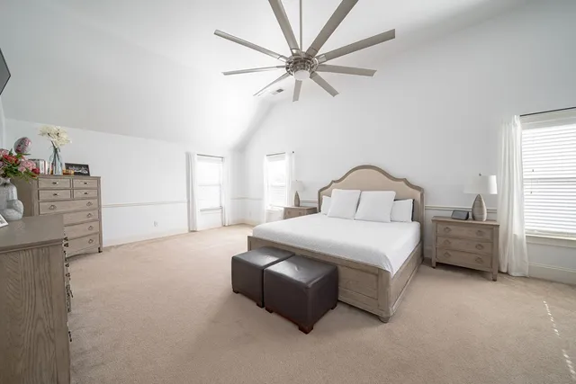 a spacious bedroom with a bed closet and flat screen tv