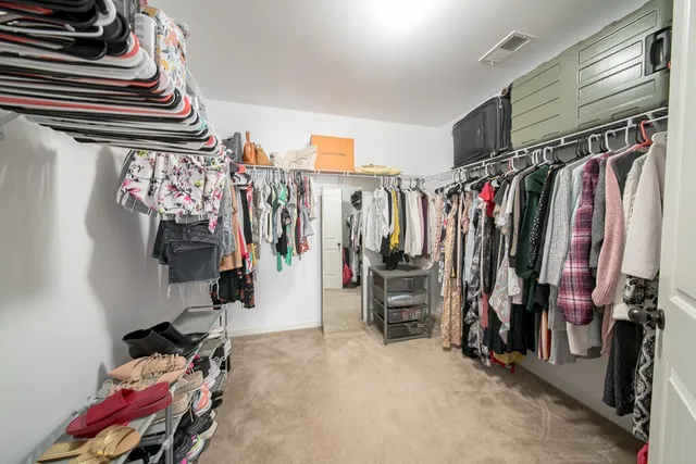a spacious bedroom with a bed and a chandelier