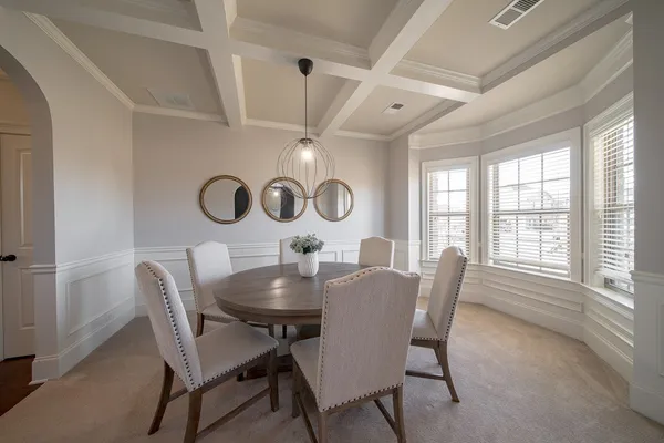 a dining room with furniture and a large window