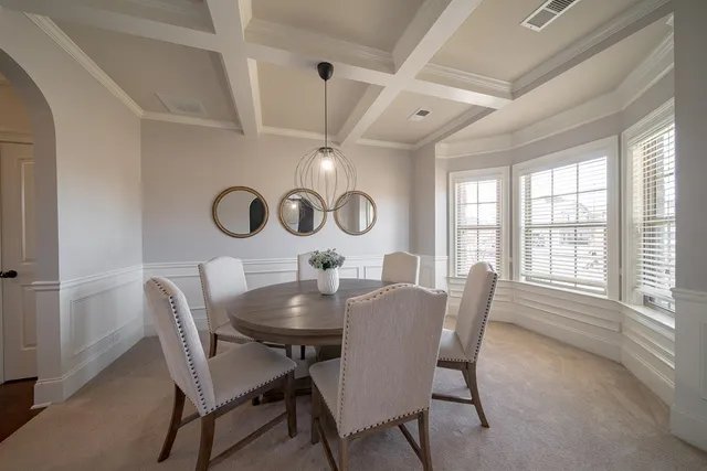a dining room with furniture and a large window