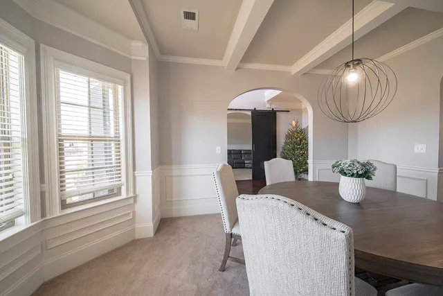 a dining room with wooden floor a chandelier a wooden table and chairs