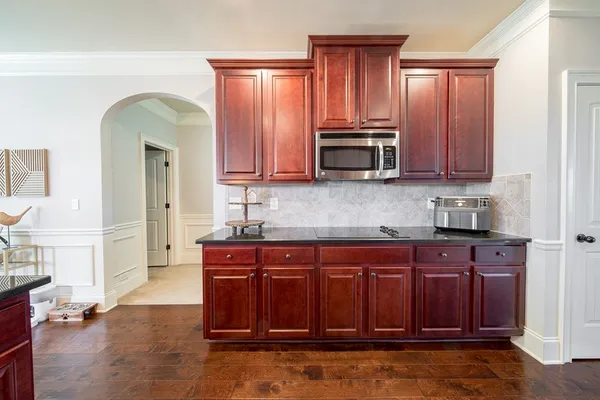a kitchen with stainless steel appliances granite countertop a stove a sink dishwasher and cabinets with wooden floor