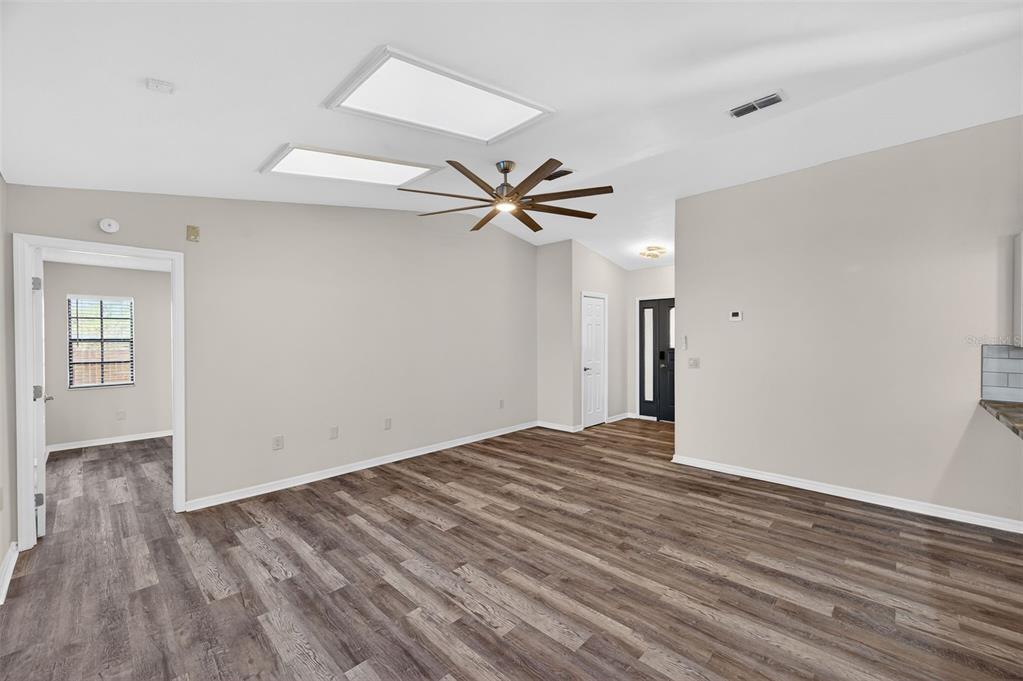 12435 Lola Drive Spring Hill, FL 34608 - Photo 11 of 63 an empty room with wooden floor and a ceiling fan