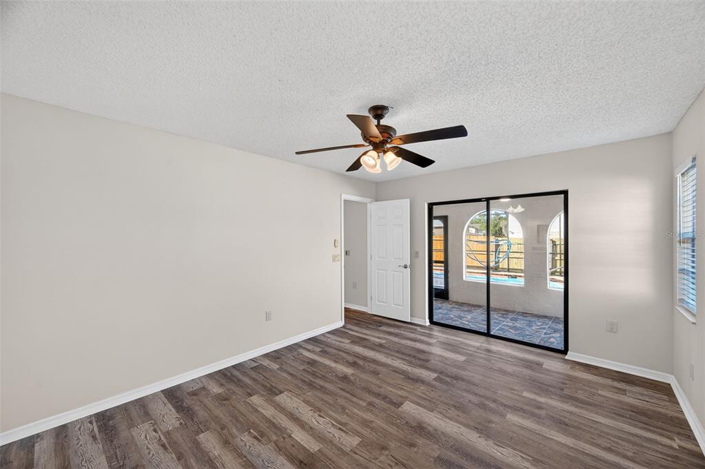 12435 Lola Drive Spring Hill, FL 34608 - Photo 23 of 63 a view of empty room with wooden floor and fan
