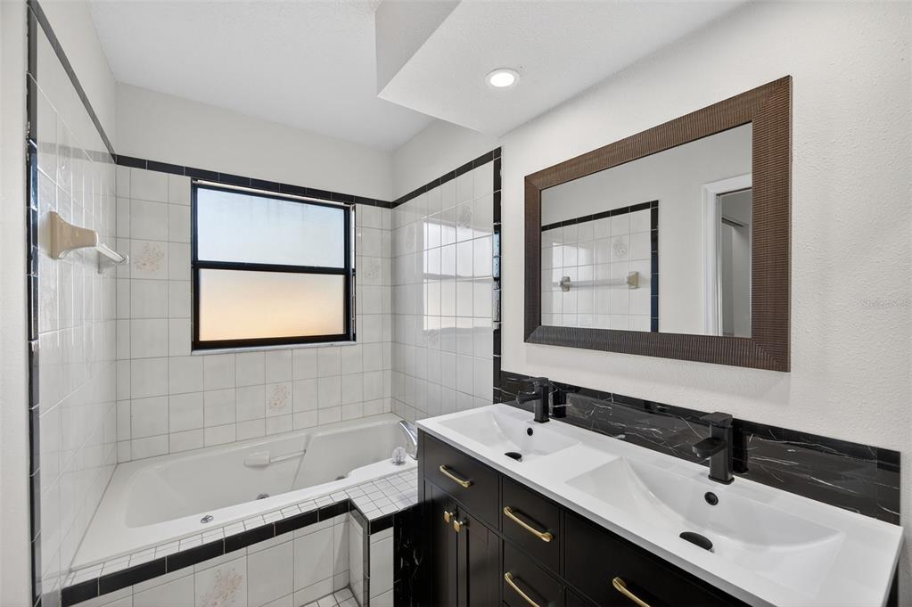 12435 Lola Drive Spring Hill, FL 34608 - Photo 26 of 63 a bathroom with a sink mirror and a bathtub