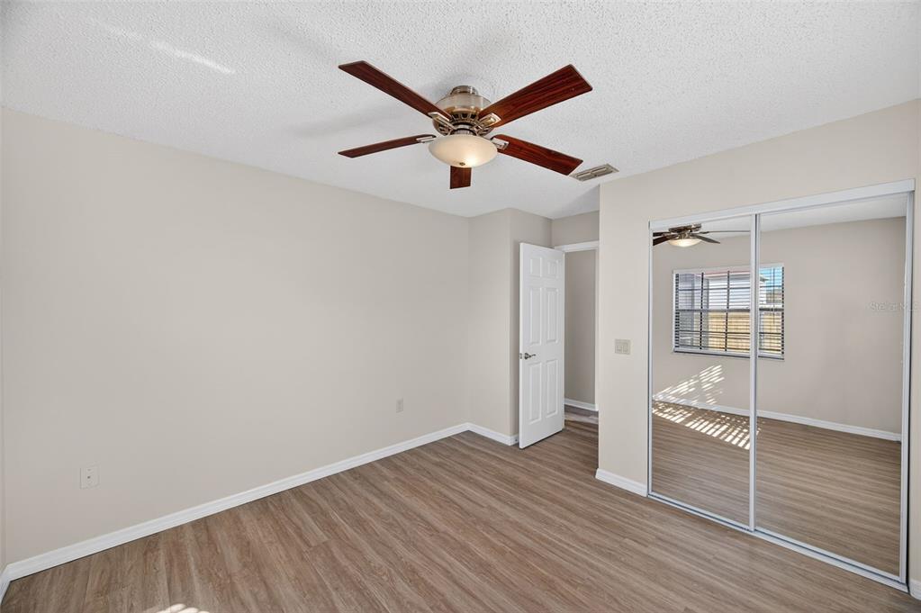 12435 Lola Drive Spring Hill, FL 34608 - Photo 31 of 63 a view of a livingroom with wooden floor and a ceiling fan