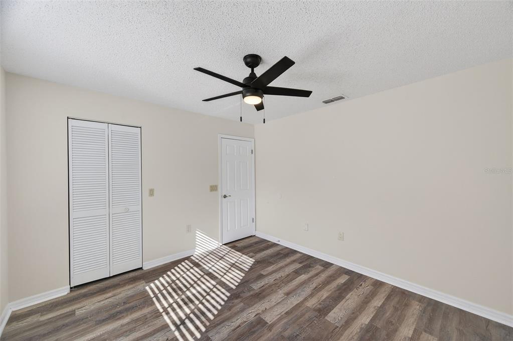 12435 Lola Drive Spring Hill, FL 34608 - Photo 36 of 63 a view of room with a ceiling fan and wooden floor