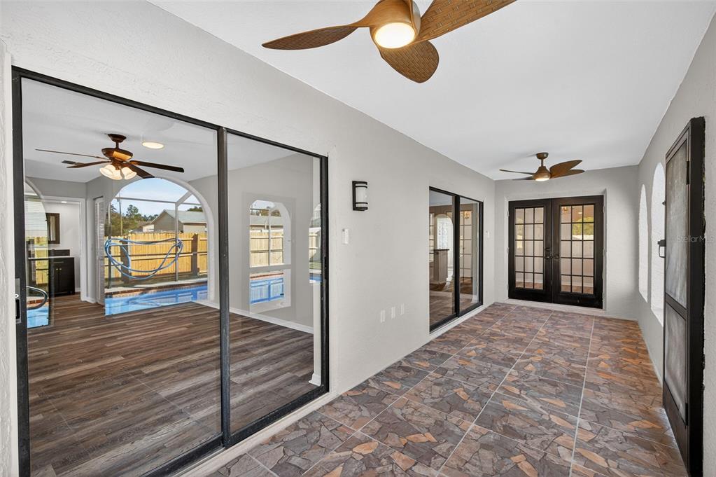 12435 Lola Drive Spring Hill, FL 34608 - Photo 45 of 63 a view of a hallway with a chandelier fan and windows