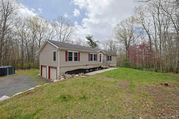 a view of a house with backyard and trees