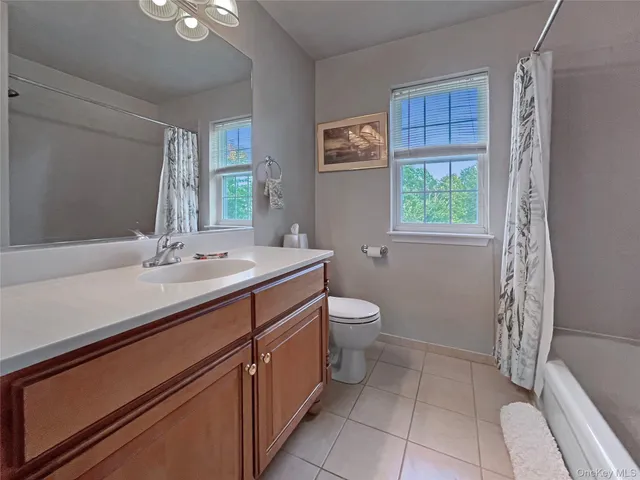 a spacious bathroom with a double vanity sink toilet and a mirror