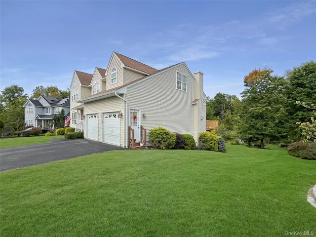 a view of a house with a big yard plants and large trees