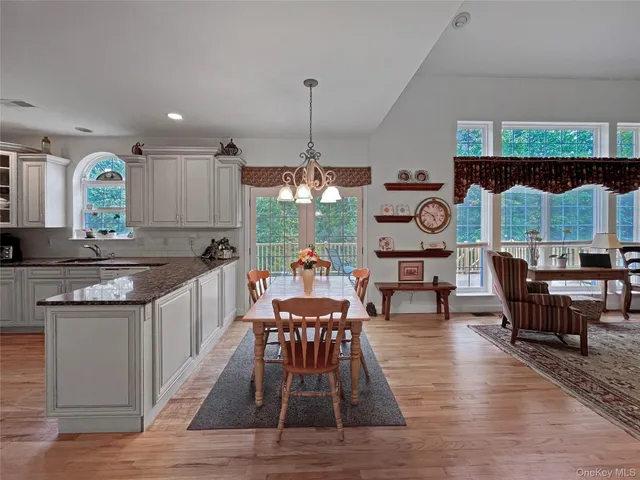 a kitchen with stainless steel appliances granite countertop table chairs and a dining table view