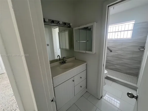 a bathroom with a sink a mirror and shower